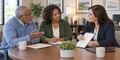 An older Maryland adult and family member asking an insurance agent questions before a Medicare plan review