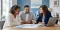 A licensed insurance professional reviewing health plan comparison papers with a Maryland couple