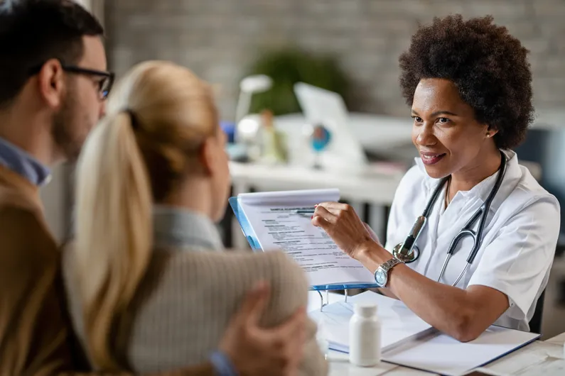 Smiling doctor explains options to patients.